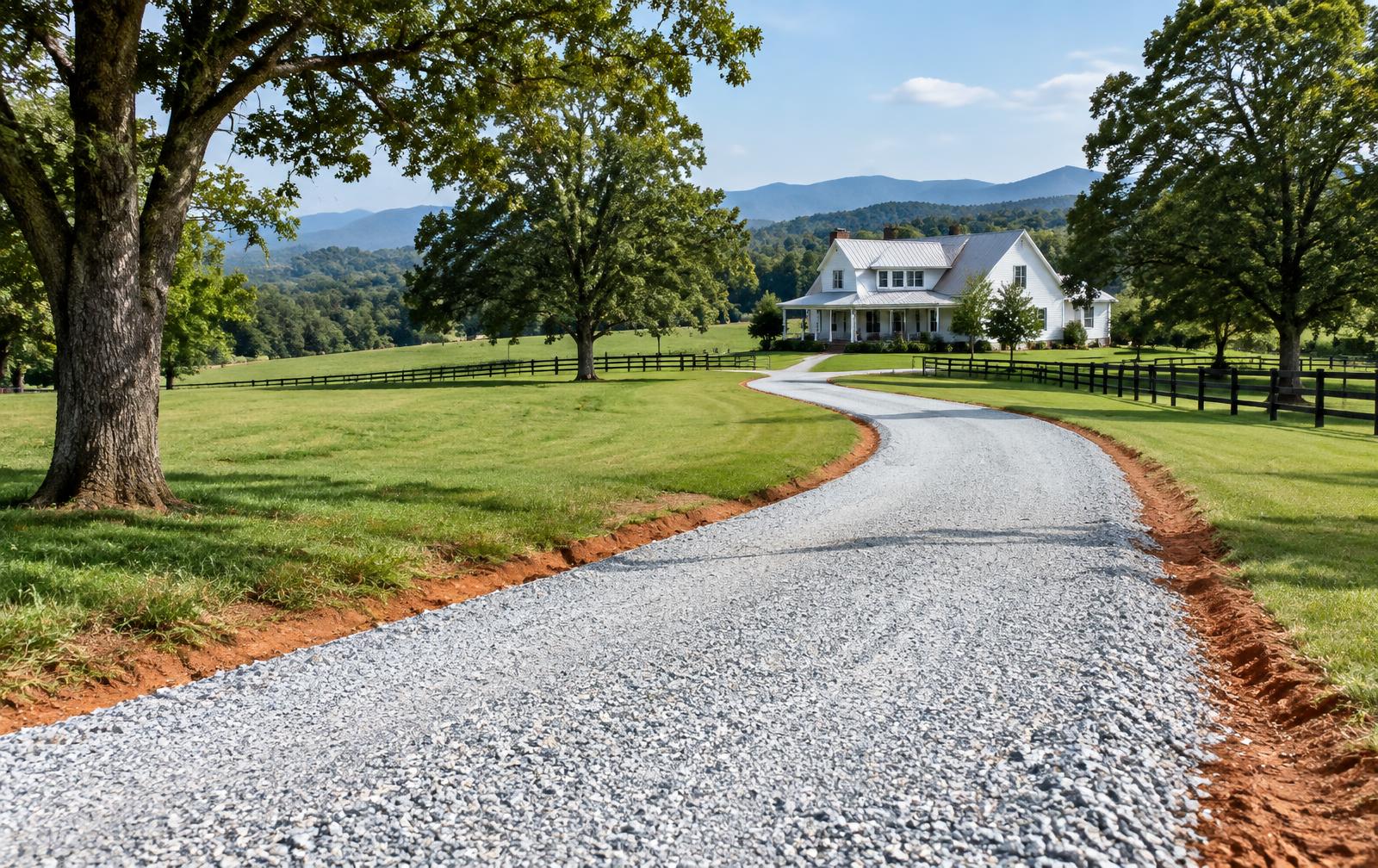 New gray gravel driveway curving through green Upstate pasture toward a farmhouse and distant foothills